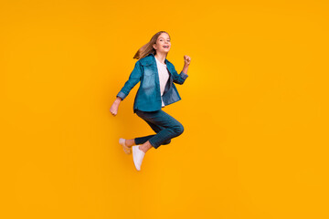 Obraz premium Full size portrait of energetic excited girl jumping running have good mood isolated on yellow color background