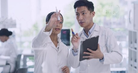 Two scientists working together using a tablet inside a modern lab. Male and female technicians doing a calculation with each other. Man and woman researchers solving a problem in a laboratory online