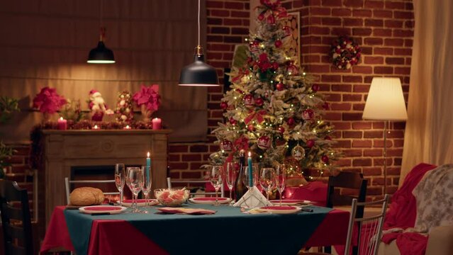 Cozy and warm looking dining room with seasonal and positive style with nobody in it. Empty interior of festive traditional Christmas dinner table with authentic decorations and dinnerware.