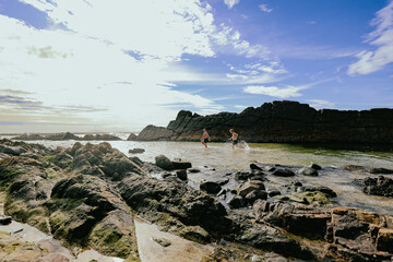 Children swimming at The Tanks tourist attraction natural rock pool at Forster, NSW Australia