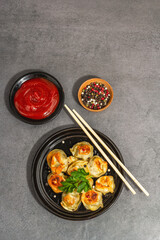 Deep-fried dumplings with tomato sauce and pepper mix. Vegan food, modern hard light, dark shadow