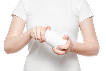 Process of opening white plastic pill bottle by woman in white t-shirt. Step 1.