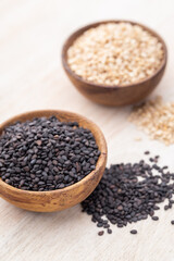 White sesame and black sesame seed on wooden bowl.