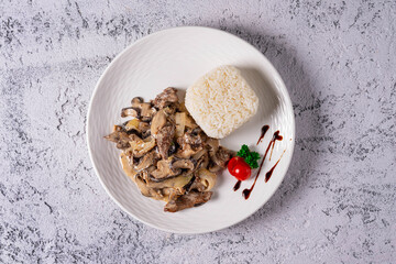 mushrooms with meat in sauce with boiled rice. on a light concrete background
