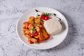 chicken meat with vegetables and boiled rice on a light concrete background
