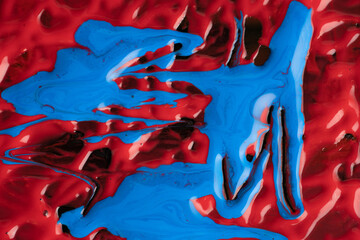 Abstract vibrant multi-color wet paint drops and splotch on black background. Bright red and blue...