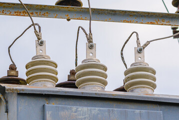 High voltage circuit breaker,insulators and conductors in a power substation.Close up.