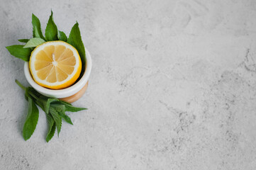 lemon and mint on gray background. copy space for text. ingredients for summer drinks