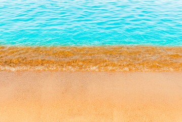 Blue sea wave,golden sand beach,white foam,turquoise ocean water.Close-up.Summer holidays concept.Tropical island vacation backdrop,tourist travel banner design template, copy space.