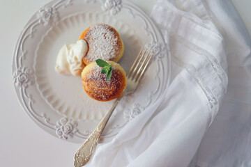 Cottage cheese pancakes, syrniki, ricotta fritters on white ceramic plate. Healthy and delicious morning breakfast. Copy space. White background. Top view, space for text, food background