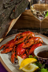 Boiled crayfish with salad and a glass of white wine
