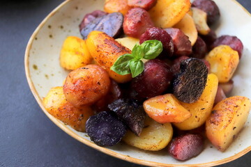 colored peeled fried potatoes close-up in clay plate selective focus