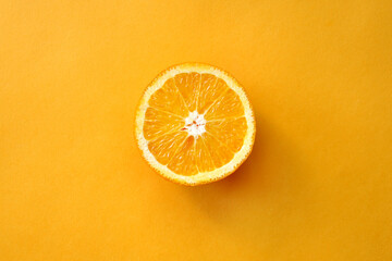 Bright, orange sliced orange on a yellow background