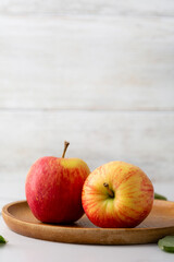 Two fresh organic apples wooden plate on light surface harvest concept food copy space