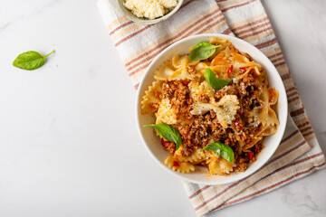 Top view of bolognese pasta in white bowl italian food on light table copy space