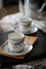 Breakfast or coffee break  in a rustic, intimate and cozy atmosphere. Cups of coffee or tea crafted on an ornate table.