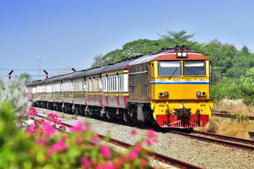 Naklejka premium Thai passenger train by diesel locomotive on the railway