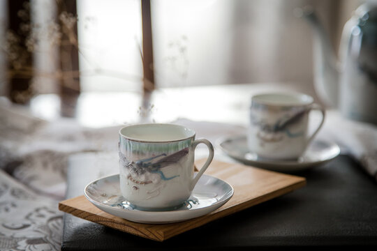 Breakfast or coffee break  in a rustic, intimate and cozy atmosphere. Cups of coffee or tea crafted on an ornate table.