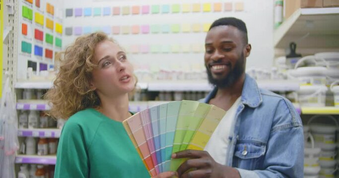 Multiethnic couple study color palette in diy store. Realtime