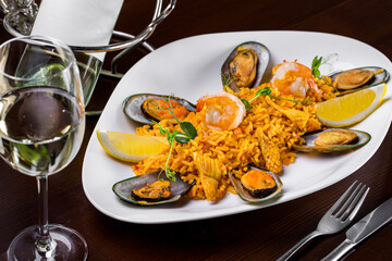 Spanish paella with seafood and a glass of wine.