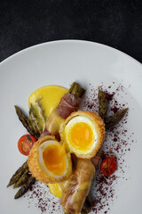 Poached egg, with asparagus, on a dark background