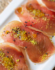 Cecina de Leon (Spanish Cured Beef Ham) with pistachio and extra virgin olive oil pearls on toasted...