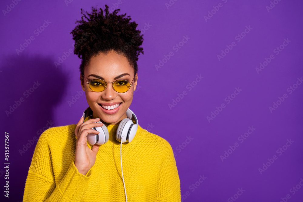 Wall mural Photo of cheerful pretty lady hand touch headphones look camera toothy smile isolated on violet color background