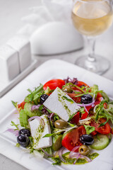 Salad with cheese, olives, onions, tomatoes, lettuce, arugula and sauce
