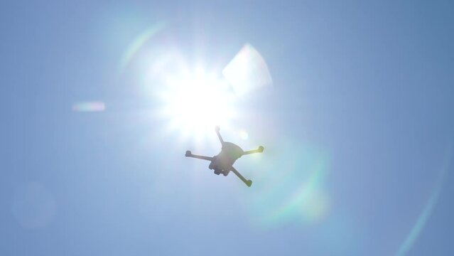 夏の強い日差しの中を飛ぶドローン