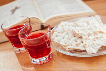 Communion with wine and bread matzo and Bible on the table, christian religion