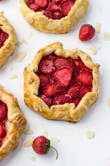 Mini biscuits with strawberries. Small berry pies on a white background.