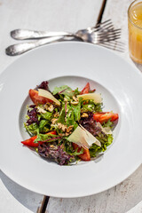 Salad with cheese, tomatoes, peppers, endive, lettuce and walnuts