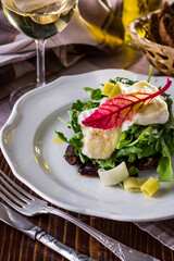 Salad with cheese, scrambled eggs, arugula, basil and olives