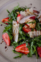 Salad with mozzarella, arugula, strawberries, wheat and sauce