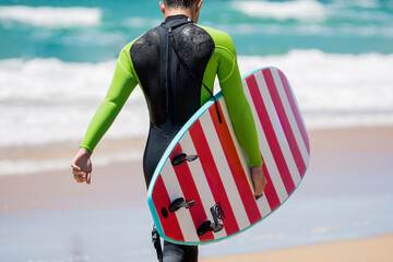 surfista en la playa con una tabla de surf de rayas 