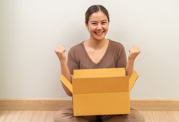 Asian women opening parcel box package, shipment service and delivery courier concept