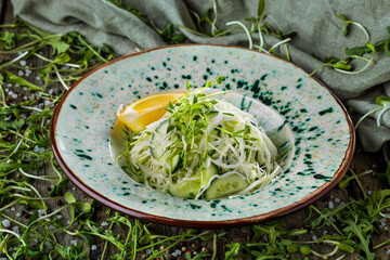 Salad with lemon, cucumbers, cabbage, and sprouts