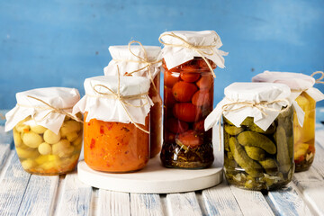 Jars of Tasty Pickled Vegetables Homemade Canned Food Blue and White Wooden Background Horizontal...