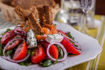 Salad with mozzarella, tomato, pepper, salmon, croutons, lettuce, basil, parsley