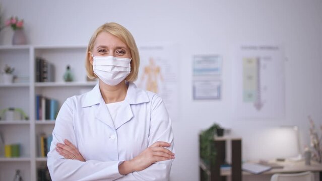 Female family therapist in medical mask smiling on camera, health care insurance