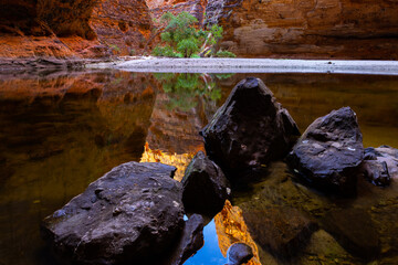 Banded beehive shaped sandstone formations reflecting in water pool in the Cathedral Gorge in the...