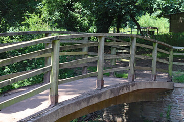 Fototapeta na wymiar A small curved wooden bridge over the river Horner at Bossington in Somerset