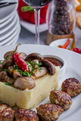 Rabbit cutlets with mashed potatoes, mushrooms and a glass of wine.