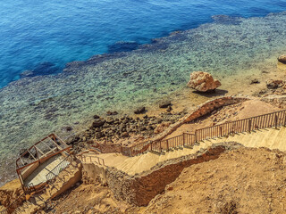 Stepped descent into the rock to the coral reef in the Red Sea in Sharm El Sheikh, Egypt. Stone...