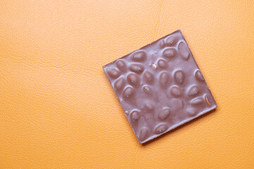 dark chocolate with almond nut on orange background 