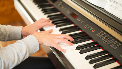 woman's hands learning piano