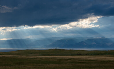 Sun rays above mountain range.  Sun light through clouds. Olkhon lake. Background nature after rain.