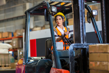 Obraz na płótnie Canvas women worker at forklift driver happy working in industry factory logistic ship. Woman forklift driver in warehouse area. 