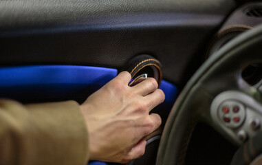 Close-up of a man's hand on the handle of the car door opener. A man opens the doors from inside the interior of a luxury car selective focus.