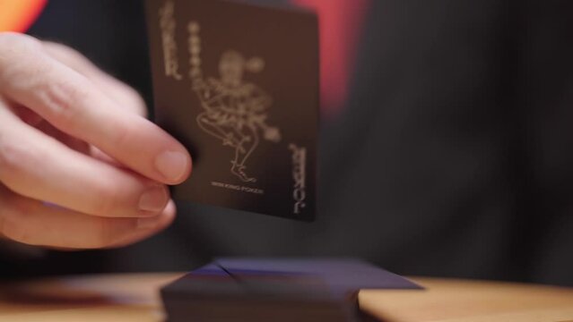 Person hand turn the last card on deck showing the joker 4K